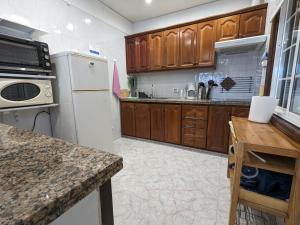 a kitchen with wooden cabinets and a white refrigerator at La Casa del Sol, Abades in Abades