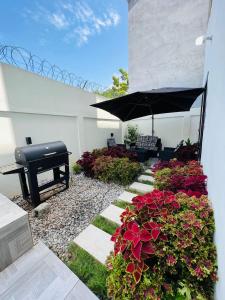 a garden with flowers and a piano and an umbrella at Charly Agla-Piscine in Cotonou
