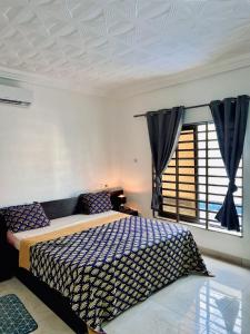 a bedroom with a bed and a window at Charly Agla-Piscine in Cotonou