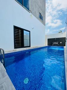 a large swimming pool with blue water in a house at Charly Agla-Piscine in Cotonou