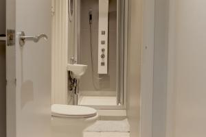 a white bathroom with a toilet and a shower at Live the London movie in Notting Hill in London