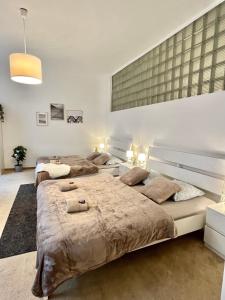 two beds in a large bedroom with two lamps at Apartment Lea - Old Town in Bratislava