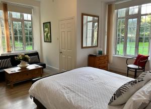 ein Schlafzimmer mit einem Bett, einem Sofa und Fenstern in der Unterkunft Exmoor Manor Guest House in Lynton