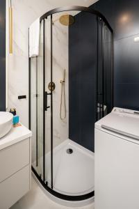 een badkamer met een douche, een toilet en een wastafel bij Platon Modern Studio in Łódź