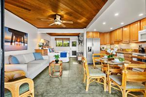 a kitchen and living room with a couch and a table at Pohailani 112 in Kahana