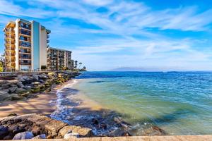 a view of a beach with a building and the ocean at Pohailani 112 in Kahana