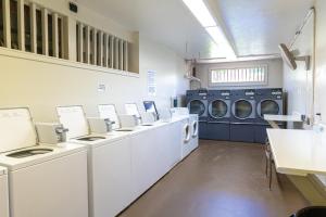 a laundry room with a row of washers and dryers at Pohailani 112 in Kahana