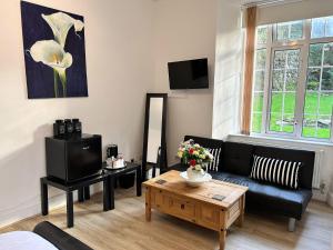 a living room with a black couch and a coffee table at Exmoor Manor Guest House in Lynton