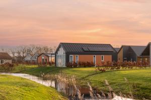 una fila de casas con paneles solares en sus tejados en Summio Villapark Akenveen en Tynaarlo