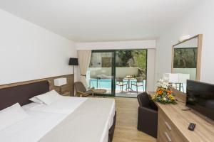 a bedroom with a bed and a tv and a living room at Calypso Palace in Faliraki