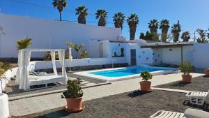 ein weißes Haus mit Swimmingpool und Palmen in der Unterkunft Beautiful 1-Bedroom House 'Oficina' Finca Vistamar in Salobre + 11 Fotos