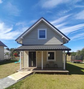 a small house with a deck in a yard at Domki 7 Houses Rewal in Rewal