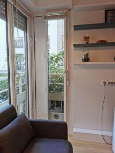 un soggiorno con divano e una grande finestra di Superbe appartement calme à République a Parigi