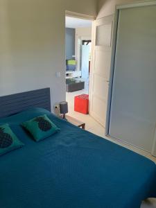 a bedroom with a blue bed with a sliding glass door at LADILAFE in Le Marin +21 photos