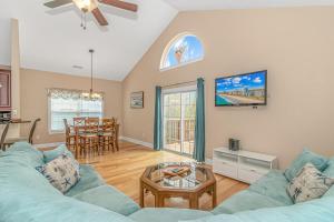 a living room with a blue couch and a table at Spacious 4 Bedroom House-2 Blocks From the Ocean-2185 Sanibel Court! in Myrtle Beach