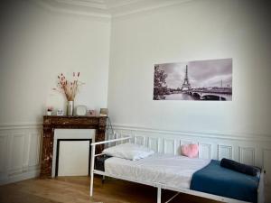 a bedroom with a bed and a picture of the eiffel tower at PARIS CITY-Le Raincy - Facing station - 4 to 8 Pers in Le Raincy