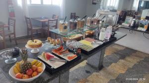 a buffet of food on a table with fruit at Hotel Imperador in Santos