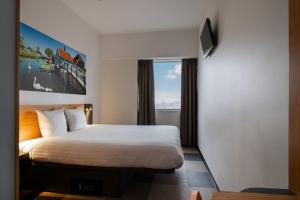 a hotel room with a bed and a window at easyHotel Amsterdam Zaandam in Zaandam