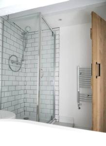 a bathroom with a shower and a toilet and a mirror at White Cottage deluxe 2 bedroom apartment in Grassington