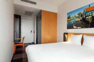 a hotel room with a bed and a desk at easyHotel Amsterdam Zaandam in Zaandam