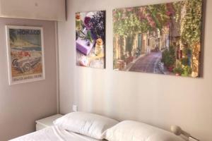 a bedroom with three pictures on the wall at Casa Charlotte nel cuore di Cannes in Cannes