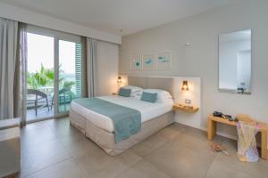 a bedroom with a large bed and a balcony at Albatros Beach Hotel in Letojanni