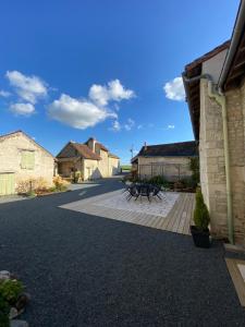 eine Terrasse mit Picknicktischen im Innenhof in der Unterkunft La Ménardière in La Tour-Saint-Gelin