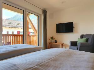 - une chambre avec un lit, une télévision et un balcon dans l'établissement Ferienhaus Berger, à Garmisch-Partenkirchen