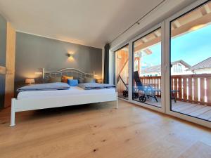 a bedroom with a bed and a balcony at Ferienhaus Berger mit eigenen Whirlpool im Garten in Garmisch-Partenkirchen