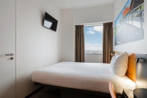 a hotel room with a bed and a window at easyHotel Amsterdam Zaandam in Zaandam