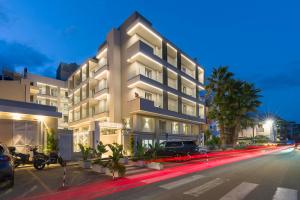 a large white building with cars parked in front of it at Albatros Beach Hotel in Letojanni