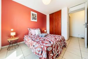 - une chambre avec un lit et un mur rouge dans l'établissement Le Valéria, à Saint-Denis