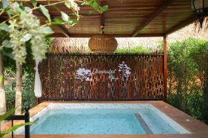 a swimming pool under a wooden pergola with at ชนบท เขาใหญ่ in Ban Tha Chang