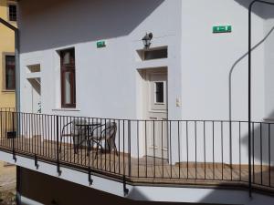 a balcony of a white building with a table at apartmány LEVOČA in Levoča