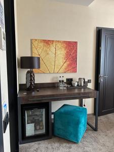a desk in a room with a table with a lamp at Noble Boutique Hotel in Lutsk