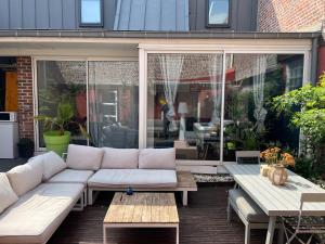 a living room with a white couch on a patio at Studio indépendant et calme avec Jacuzzi à Lille in Lille