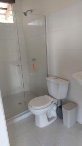 uma casa de banho branca com um WC e um chuveiro em Puerta al Mar Ecolodge Glamping em Tubará