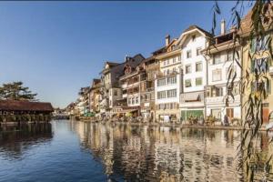 a view of a river with houses and buildings at House of Thun Full Apartment in Thun