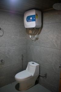 a bathroom with a toilet and a paper dispenser on the wall at The Grand ARK in Gangtok