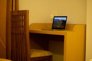 a laptop computer sitting on a desk with a chair at The Grand ARK in Gangtok