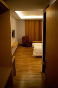 uma sala com um quarto com uma cama e uma cadeira em The Grand ARK em Gangtok