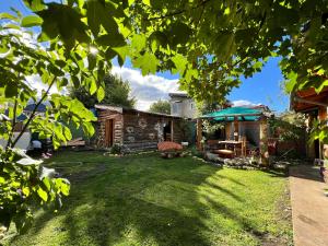 a backyard of a house with a grass yard at Ankatu Hostel in El Bolsón