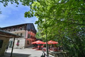 ein Gebäude mit Tischen und Sonnenschirmen vor einem Gebäude in der Unterkunft Luisenburg Resort in Wunsiedel