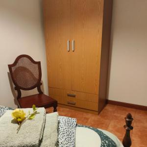 Casinha da Ladeira 3360 في بيناكوفا: غرفة نوم بسرير وكرسي وخزانة