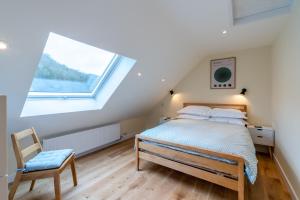 a bedroom with a bed and a large window at The Weir House in Symonds Yat