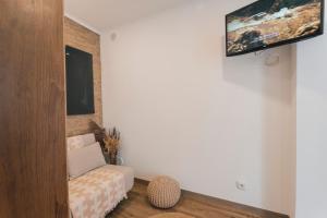 a living room with a couch and a tv on a wall at Best Houses 77 - Best Village I in Peniche