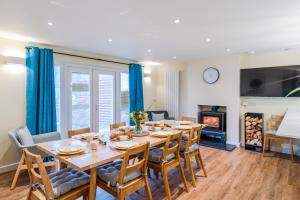 a dining room with a table and chairs and a fireplace at The Weir House in Symonds Yat