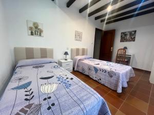 サンティリャーナ・デル・マルにあるCasa La Ranera de Santillanaのベッドルーム1室(ベッド2台、テーブル、椅子付)