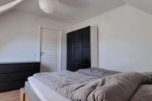 a bedroom with a large bed and a black cabinet at Newly renovated, great location in Aalborg