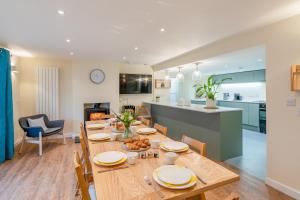 a dining room and living room with a wooden table at The Weir House in Symonds Yat